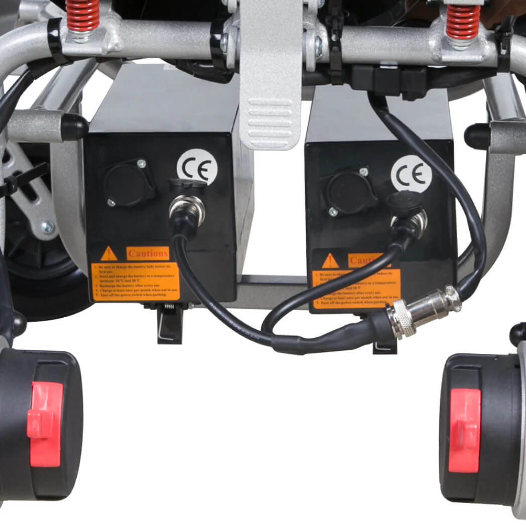 The rear bottom of the wheelchair with one double end cable connecting to 2 batteries